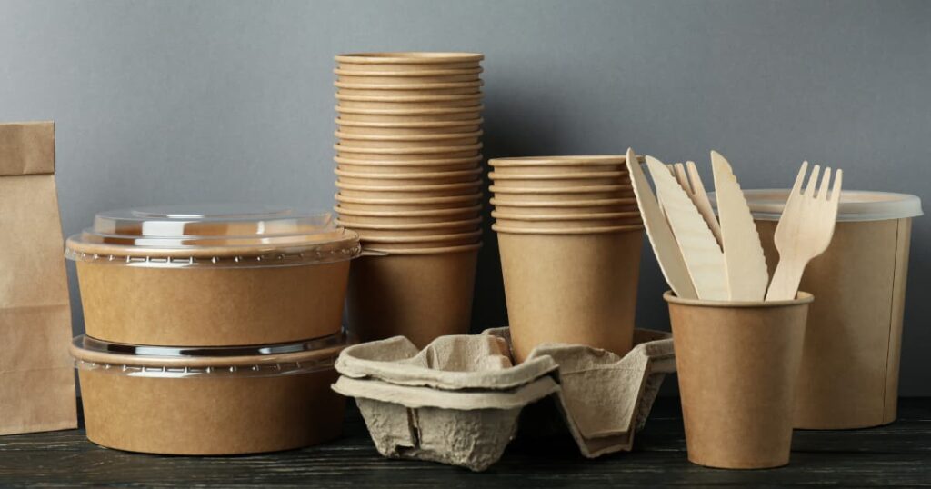 A variety of eco-friendly biodegradable packaging products including cups, bowls, and cutlery.